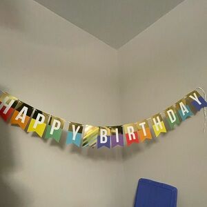Colorful “Happy Birthday” Banner. The letters are white With gold accent on each